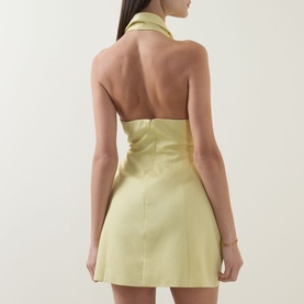Model wearing Odd Muse Shawl Zip Sculpted Mini Dress in lemon, showing open back, shawl collar, and structured mini silhouette.