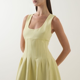 Model wearing Odd Muse Cinched Pleated Dress in Lemon, featuring scoop neckline, sleeveless cut and boned cinched bodice with pleated skirt.