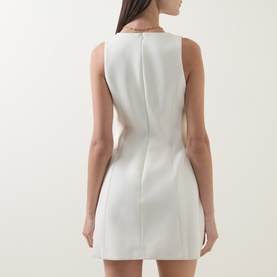 Model wearing Odd Muse Volume Mini Dress in ecru, rear view showing back zip fastening, darting detail and structured mini skirt silhouette.