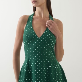 Model wearing Odd Muse Volume Polka Dot Tie-Neck Dress in Green Polka Dot; V-neckline, halter tie, sleeveless, flared structured skirt visible.