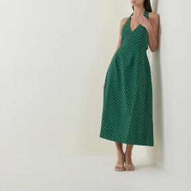 Model wearing Odd Muse Volume Polka Dot Tie-Neck Dress in green polka dot, midi length with flared skirt, styled with nude heeled sandals