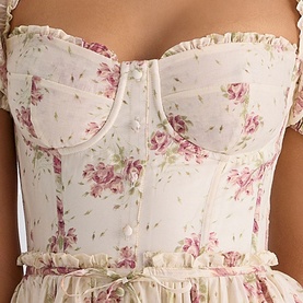 Model wearing House of CB Ivory Vintage Rose floral corset top with ruffle trim, button front, and thin straps, paired with matching skirt