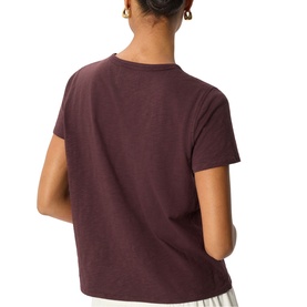 Model wearing Whistles red short-sleeve crew neck T-shirt, back view, styled with white trousers