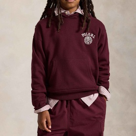 Model wearing Ralph Lauren Big Fit Crest Logo Fleece Hoodie in Rich Ruby with matching joggers and striped shirt underneath.