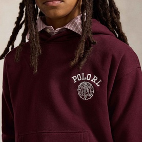 Model wearing Ralph Lauren Big Fit Crest Logo Fleece Hoodie in Rich Ruby with embroidered crest logo, styled over a checked shirt.