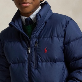 Model wearing Ralph Lauren navy quilted puffer jacket with zip chest pocket and red embroidered Polo Pony logo, styled with shirt and tie