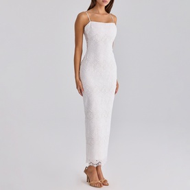 Model wearing House of CB white lace maxi dress with spaghetti straps and scalloped hem, styled with nude heeled sandals