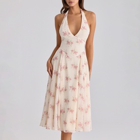 Model wearing cream halterneck midi dress with pink floral print, V-neckline, fitted waist and full pleated skirt