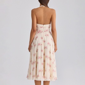 Model wearing cream halterneck midi dress with pink floral print, open back, fitted bodice and flared skirt, shown from behind