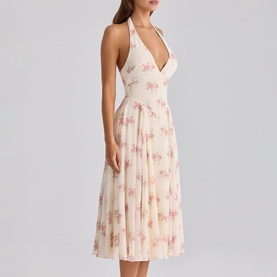 Model wearing cream halterneck midi dress with pink floral print, deep V-neckline, and pleated skirt