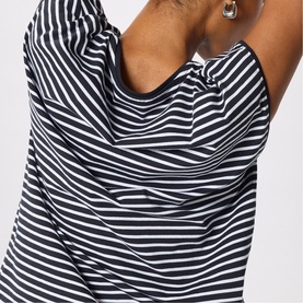Model wearing Whistles blue and white stripe top, close-up of draped neckline detail, arms raised showing relaxed fit
