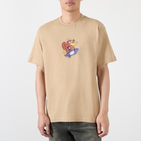 Model wearing Vans beige cotton T-shirt with cartoon character graphic print on chest, styled with dark jeans.