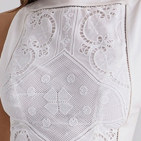 House of CB white top with intricate broderie anglaise and crochet lace detailing, close-up of bodice