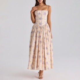 Model wearing blush floral print corset-style midi dress with spaghetti straps, fitted bodice and full pleated skirt