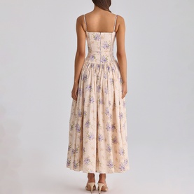 Model wearing blush pink floral print strappy midi dress with gathered skirt, shown from the back, featuring purple floral motifs