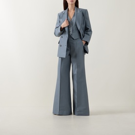 Model wearing slate blue wide-leg suit trousers styled with a matching blazer and waistcoat
