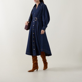 Model wearing Zimmermann Belted Denim Shirt Dress in Harbour Blue with D-ring belt, styled with tan knee-high boots and small burgundy bag.