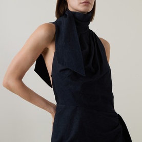 Model wearing Zimmermann Dress in Night Sky, featuring a draped high neck and open back in textured cotton fabric.