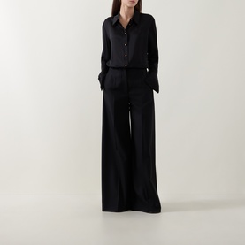 Model wearing Zimmermann Valiant Silk Shirt in black with classic collar, flared cuffs, styled with matching wide-leg black trousers.