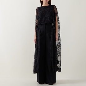 Model wearing Zimmermann Valiant Lace Caped Blouse in black with scalloped lace cape sleeves, styled with a black wide-leg skirt.