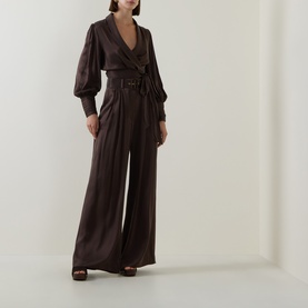 Model wearing Zimmermann Bitter Chocolate silk top with wide-leg trousers and belted waist, styled with brown heeled sandals