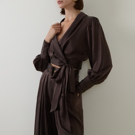 Model wearing Zimmermann silk wrap top in Bitter Chocolate, styled with matching wide-leg trousers and tied waist detail