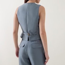Model wearing Zimmermann Valiant Single-Breasted Waistcoat in Airforce, rear view showing back buckle strap detail and mock welt pockets with
