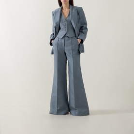 Model wearing Zimmermann Valiant Structured Flared Leg Trousers in Airforce, styled with matching blazer and vest, full-length flared silhouette