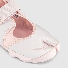 Pale pink split-toe strap sandal with mesh upper, velcro fastening, and smooth toe cap detail, close-up shot