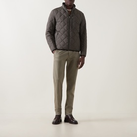 Model wearing Bugatti Air Series Diamond Quilted Jacket in olive with stand-up collar, styled with khaki trousers and dark brown leather shoes.