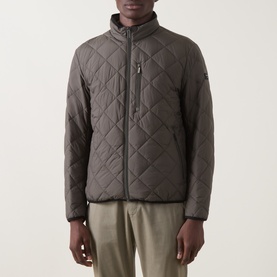 Model wearing Bugatti Air Series Diamond Quilted Jacket in olive with stand-up collar, full zip, and diamond quilted finish, styled with light
