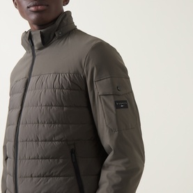 Model wearing Bugatti Dynamic Padded Jacket in olive, featuring stand collar, quilted construction, and sleeve pocket with snap button detail