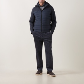 Model wearing Bugatti Blue Quilted Hooded Jacket with horizontal quilting, styled with navy trousers and grey top.