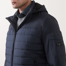 Model wearing Bugatti Quilted Hooded Jacket in blue, showing horizontal quilting, sleeve flap pocket with logo, and layered hood detail.