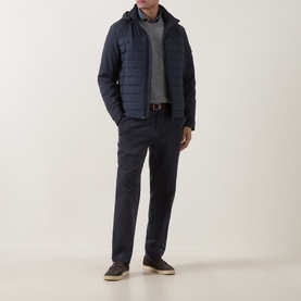 Model wearing Bugatti Blue Quilted Hooded Jacket with grey knit, navy trousers, brown belt and dark loafers.
