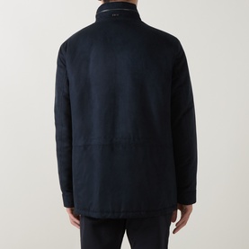 Model wearing navy blue wool-blend jacket, rear view, showing stand collar, zip fastening, and patch pockets