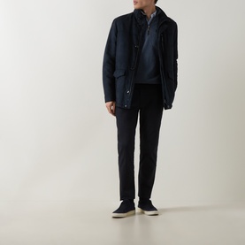 Model wearing navy quilted jacket, styled with navy knitwear, dark trousers and navy suede trainers