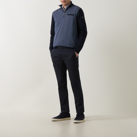 Model wearing a navy blue half-zip pullover with contrast panelling, styled with dark trousers and navy shoes
