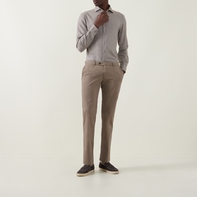 Model wearing Bugatti Micro Flex Slim-Leg Chinos in beige, styled with a grey shirt and dark loafers