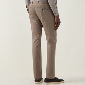 Model wearing Bugatti Micro Flex Slim-Leg Chinos in beige, rear view, styled with a grey shirt and dark loafers.
