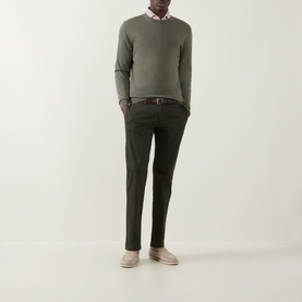Model wearing Bugatti Micro Flex Slim-Leg Chinos in green, styled with an olive crew-neck knit, white shirt, brown belt, and beige loafers.