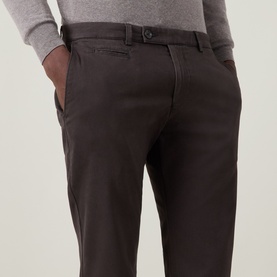 Model wearing Bugatti Micro Flex Slim-Leg Chinos in brown, slim-leg cut with belt loops and side pockets, styled with a grey knit top.