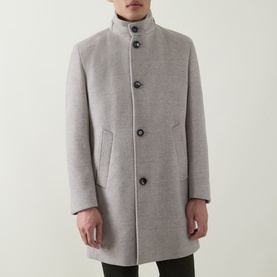 Model wearing Bugatti Logo Longline Coat in stone, featuring stand-up collar, front button fastening and angled welt pockets.