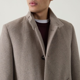 Model wearing Bugatti beige wool-blend coat with notched lapel collar, styled over burgundy knitwear and white T-shirt.