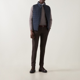 Model wearing Bugatti Air Series Padded Gilet in navy with funnel neck and quilted design, styled with grey jumper and brown trousers.