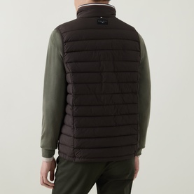 Model wearing Bugatti brown quilted gilet, rear view, styled with olive green long-sleeve top and matching trousers