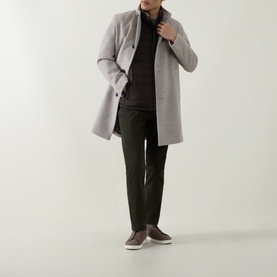Model wearing Bugatti brown gilet under a light grey overcoat, styled with dark trousers and brown trainers.