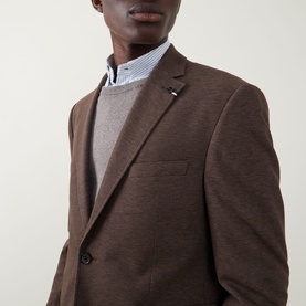 Model wearing Bugatti Birdseye Single-Breasted Blazer in brown, styled with a grey knit jumper and striped collar shirt.