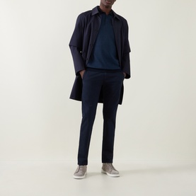 Model wearing Bugatti Textured Polo Shirt in Navy Blue with matching navy trousers and navy overcoat, styled with grey trainers.