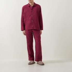 Model wearing Calvin Klein Flannel Check Print Pyjama Set in Established Red plaid, paired with taupe mule slippers